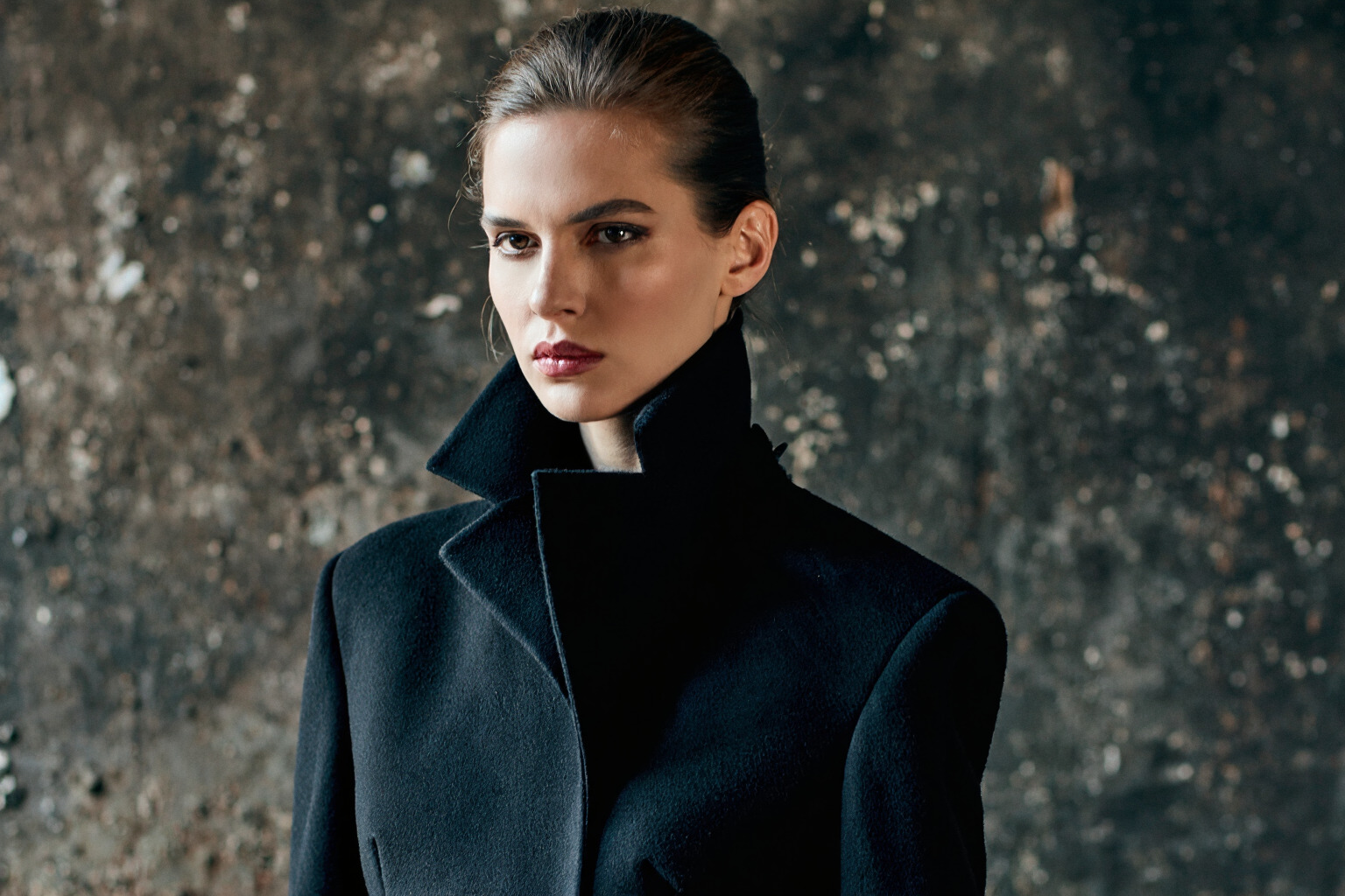 Fashion example prompt result showing a close portrait against a dark textured wall with dramatic side lighting