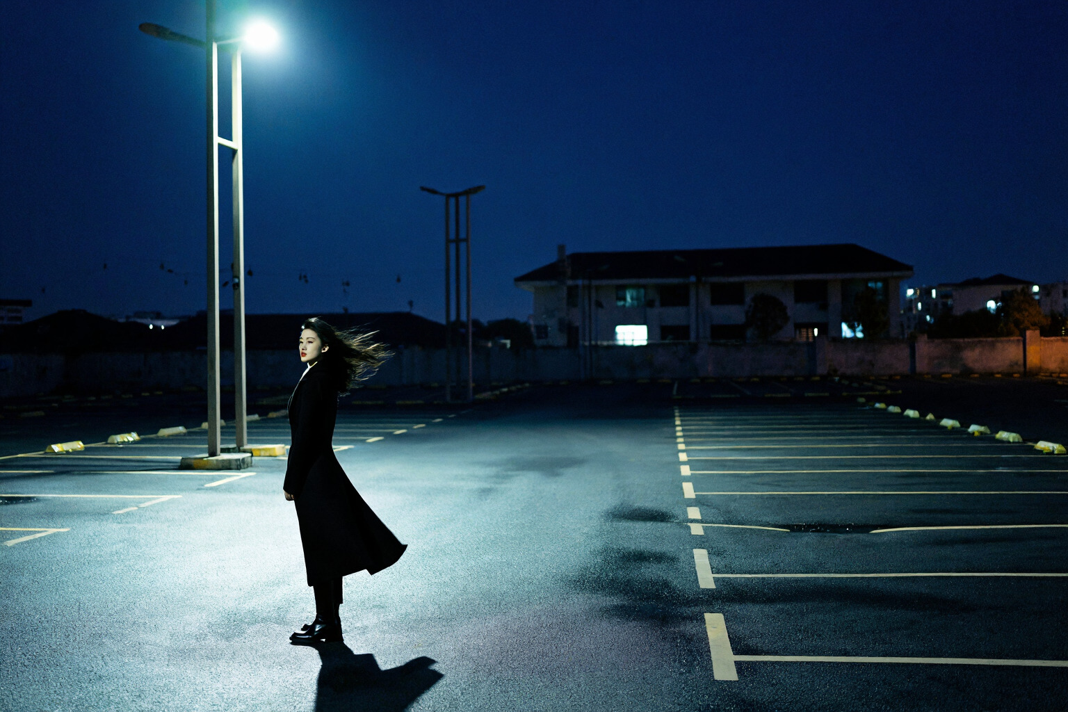Cinematic character example prompt result showing a woman beneath a streetlight in an empty parking lot