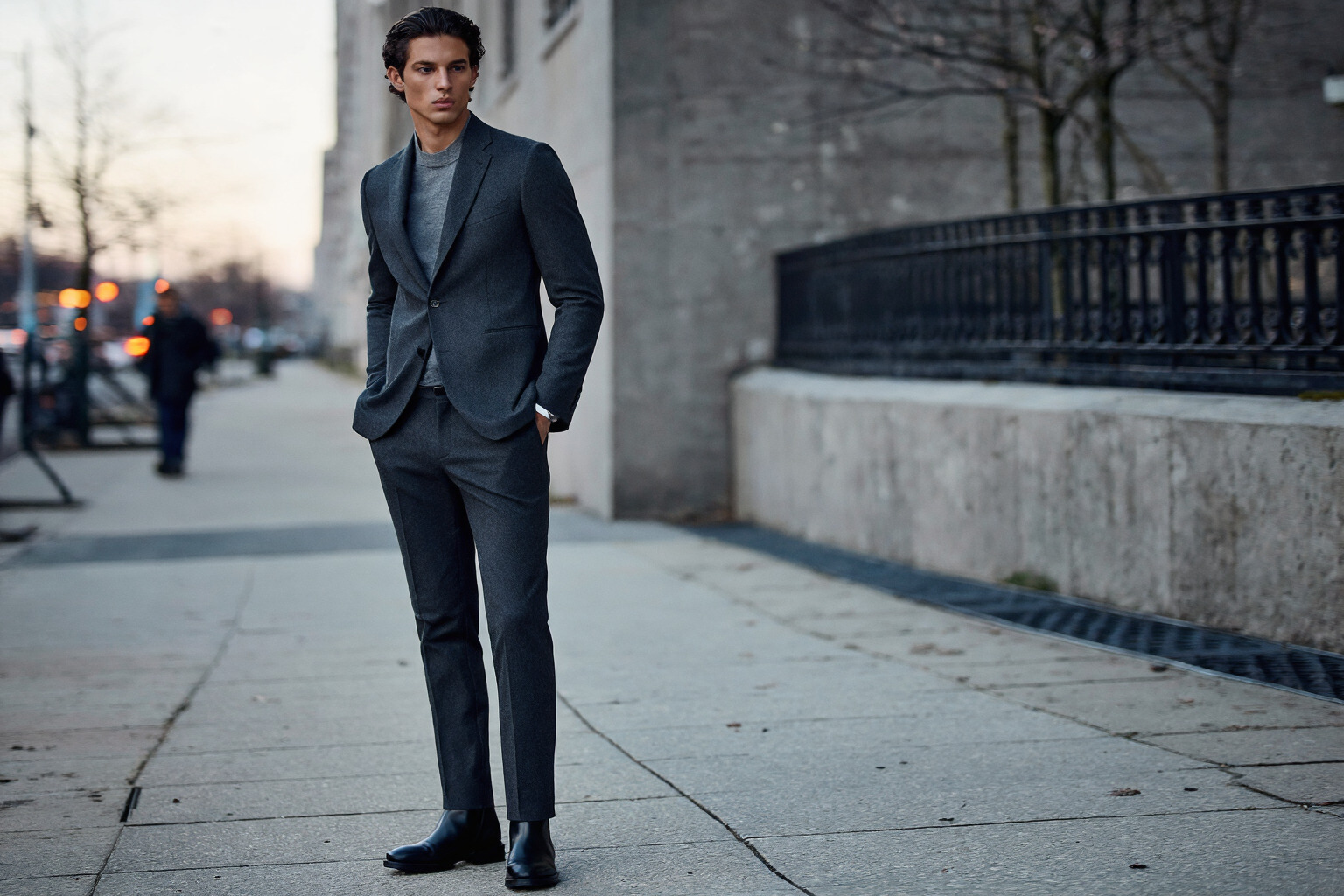 Fashion example prompt result showing a full-body city sidewalk portrait in a charcoal suit