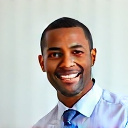 professional headshot of a smiling african american man in his 30s with short hair, wearing business casual attire, neutral background